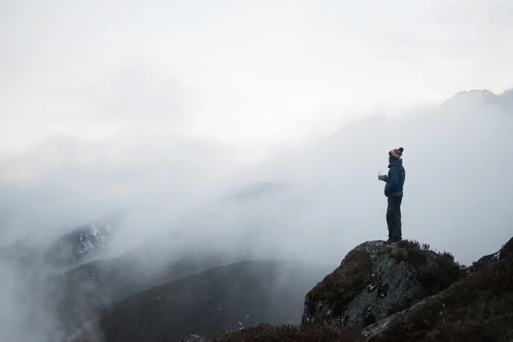 Standing on top of a mountain in the mist